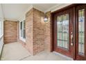 Inviting covered front porch with brick detail, outdoor sconce lighting, and a beautiful stained glass front door at 11117 Harriston Dr, Fishers, IN 46037