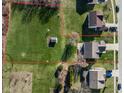 Expansive aerial view of a large, grassy lot, with a shed, surrounded by mature trees and neighboring homes at 11124 Deer Valley Dr, Indianapolis, IN 46229