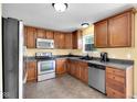 Well-lit kitchen with stainless steel appliances, wood cabinetry and tile flooring at 11124 Deer Valley Dr, Indianapolis, IN 46229