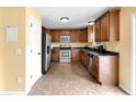 Well-equipped kitchen with wood cabinetry, stainless steel appliances, tile flooring and yellow walls at 11124 Deer Valley Dr, Indianapolis, IN 46229