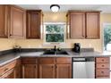 Kitchen featuring wood cabinets, stainless steel dishwasher, double sink and view out the window at 11124 Deer Valley Dr, Indianapolis, IN 46229