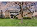 Charming exterior of a brick home with a manicured lawn and lovely landscaping details at 12535 Glendurgan Dr, Carmel, IN 46032