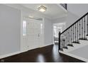 A bright foyer featuring dark hardwood floors, white trim, and a staircase at 12535 Glendurgan Dr, Carmel, IN 46032