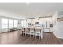 Open-concept kitchen with island seating, white cabinets and stainless appliances at 12988 Fernie Cir, Fishers, IN 46037