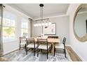 Bright dining area with natural light, stylish lighting, and seating for six around a wood table at 14477 Stairbridge Pl, Carmel, IN 46032