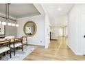 Open concept dining room with wood floors, modern lighting, and a clear view into the connected living spaces at 14477 Stairbridge Pl, Carmel, IN 46032