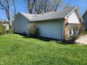 Exterior view of a home with vinyl siding, complemented by a lush green lawn and mature bushes at 1657 Park Terrace Ct, Indianapolis, IN 46229