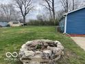 Spacious backyard with a rustic stone fire pit, perfect for outdoor gatherings at 3014 Arbor Ave, Indianapolis, IN 46217