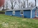 The exterior side showcases the blue siding, white trim and a well-maintained lawn at 3014 Arbor Ave, Indianapolis, IN 46217
