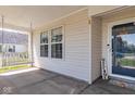 Close-up of a cozy front porch with a swing, a welcome mat, and a view of the front door at 329 Dogwood Dr, Pendleton, IN 46064