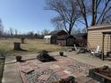 Backyard featuring a spacious lawn, multiple storage sheds, and mature trees, offering privacy and space at 445 E 1000 N, Alexandria, IN 46001