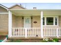 Close-up of the covered front porch with a white railing and inviting entrance at 453 S High School Rd, Indianapolis, IN 46241