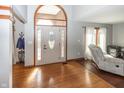 Bright foyer featuring hardwood floors, coat rack, and a glimpse of the living room at 4644 S Grassy Ct, New Palestine, IN 46163