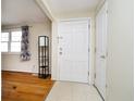 Bright entryway featuring tile flooring and coat closet, complemented by hardwood floors in the living area at 5061 Sylvan Rd, Indianapolis, IN 46228