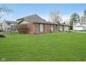 Spacious lawn surrounding a beautiful red brick home with an attached two-car garage at 5061 Sylvan Rd, Indianapolis, IN 46228