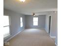 Spacious living room is illuminated by natural light through large windows and ceiling fan, perfect for relaxation at 5523 Epperson Ct, Indianapolis, IN 46221