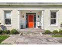 Close-up of the bright orange front door with stone walkway and manicured landscaping at 5952 Stafford Rd, Indianapolis, IN 46228