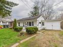Cozy home featuring tidy landscaping, an attached garage, and a paved driveway leading up to it at 612 Woodlawn Dr, Anderson, IN 46012