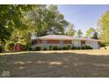 Traditional home featuring a lush front lawn, complemented by a shed, and charming brick and stone accents at 6144 S Irwin St, Indianapolis, IN 46237