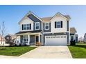 Charming two-story home with a manicured lawn, covered porch, and attached two-car garage at 6767 Sonora Blvd, Brownsburg, IN 46112