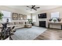 Bright living room with a fireplace, modern decor, neutral sectional, and luxury vinyl flooring at 6767 Sonora Blvd, Brownsburg, IN 46112