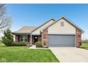 Charming single-Gathering home featuring a well-manicured lawn, brick accents, and an attached two-car garage at 8660 Benjamin Ln, Avon, IN 46123