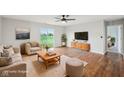 Staged living room with cozy furniture, hardwood floors, a ceiling fan, and lots of natural light at 8660 Benjamin Ln, Avon, IN 46123