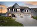 Charming two-story home with two-car garage and well-manicured lawn at dusk at 8853 Boylan Pl, Pendleton, IN 46064