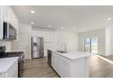 Modern kitchen with stainless steel appliances, a large island, and hardwood floors at 9738 Behner Dr, Fishers, IN 46250