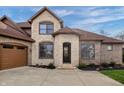 Grand entrance featuring stone accents, arched doorway and a three-car garage at 9877 Wading Crane Ave, Fishers, IN 46055