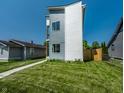 Side view of a modern two-story home showcasing its well-manicured lawn and modern architectural design at 1026 St Peter St, Indianapolis, IN 46203