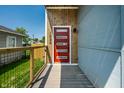 Modern home entrance with a vibrant red door, wooden accents, and a secure, gated entry, enhancing curb appeal at 1026 St Peter St, Indianapolis, IN 46203