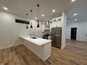 Modern kitchen features white cabinets, stainless steel appliances, and an island with a sink at 1026 St Peter St, Indianapolis, IN 46203