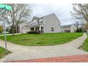 View of the gray two-story home on a corner lot, showing the green grass and landscaped yard at 11188 Giddings Pl, Noblesville, IN 46060