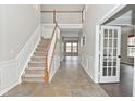 Inviting foyer with tile flooring, stairway and high ceilings at 11188 Giddings Pl, Noblesville, IN 46060