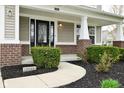 Close up of the front door with a large window, columns and a freshly landscaped yard at 11188 Giddings Pl, Noblesville, IN 46060