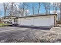 Three car garage attached to a well maintained white brick home at 11921 Westwood Dr, Carmel, IN 46033