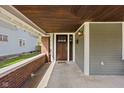 Inviting front porch with brick accents, a stained wood ceiling, and ample space at 1230 N Temple Ave, Indianapolis, IN 46201