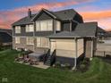 Beautiful backyard with hot tub, covered patio, and landscaped lawn at sunset at 14747 Harvest Glen S Blvd, Fishers, IN 46037