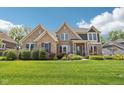 Charming brick home with manicured lawn, beautiful landscaping, and classic architectural details at 14747 Harvest Glen S Blvd, Fishers, IN 46037