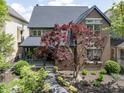 A high-angle daytime shot captures the brick facade, lush landscaping, and inviting front porch of this charming home at 1537 Carrollton Ave, Indianapolis, IN 46202