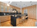 Modern kitchen with sleek stainless steel appliances, an island with bar seating, and light wood cabinets at 1537 Carrollton Ave, Indianapolis, IN 46202