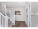 Bright foyer featuring hardwood floors, a staircase with white railings and a glass-paneled front door at 1695 Jackson St, Fortville, IN 46040