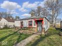 Quaint single-Gathering home with a stone foundation and red trim around the windows and door at 2429 N Arsenal Ave, Indianapolis, IN 46218