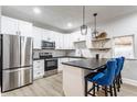 Modern kitchen with stainless steel appliances, white cabinets and a breakfast bar with blue bar stools at 310 W Staat St, Fortville, IN 46040
