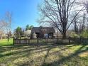 View of the rear of the house and backyard showcasing a wooden fence and established trees at 3395 State Road 44, Martinsville, IN 46151
