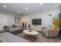 Inviting living room featuring a modern TV and cabinet, with stylish decor and wood flooring at 3636 N Chester Ave, Indianapolis, IN 46218