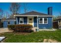 Inviting blue single-story home with a bright yellow front door and a well-kept yard at 3712 N Olney St, Indianapolis, IN 46218