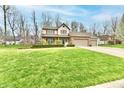 Inviting two-story home features a well-manicured lawn, and mature trees in a suburban neighborhood at 381 Stoneybrook Grove Dr, Greenwood, IN 46142