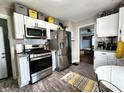 Bright kitchen features stainless steel appliances, modern white cabinets, and wood-look floors at 3949 Fletcher Ave, Indianapolis, IN 46203